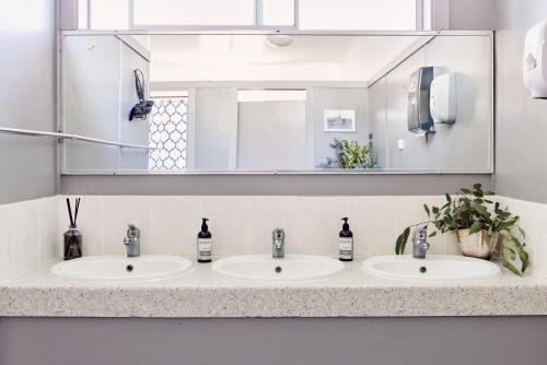 a bathroom with two sinks and a large mirror at Tenterfield Lodge Caravan Park in Tenterfield