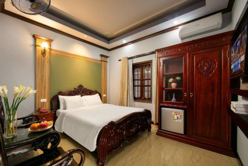 a bedroom with a bed and a cabinet and a television at Nam Hai Hotel in Hanoi