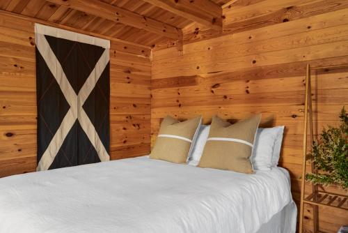 a bedroom with a bed in a log cabin at Tenterfield Lodge Caravan Park in Tenterfield