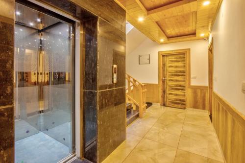 uma cabina de duche ao nível do chão num quarto com uma porta de vidro em MATSYA MANALI em Palchān
