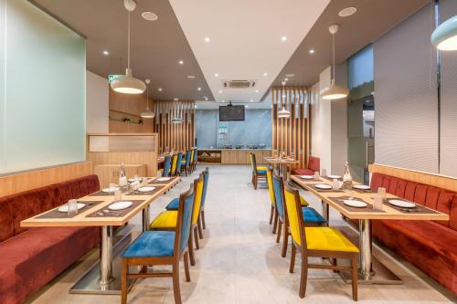 a dining room with long tables and yellow chairs at WESTSIDE HOTEL HiTECH CITY in Hyderabad