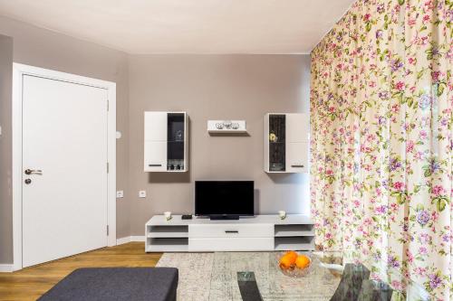 een woonkamer met een tv en een gordijn bij Guest apartment "Perunika" in Plovdiv