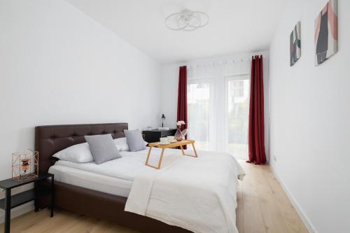 a bedroom with a bed with a table on it at Stylish Apartment with Parking in Katowice by Renters in Katowice