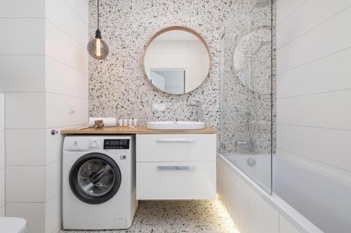 a bathroom with a washing machine and a mirror at Stylish Apartment with Parking in Katowice by Renters in Katowice