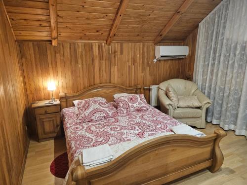um quarto com uma cama e uma cadeira em Upeslīči atpūtai em Jelgava