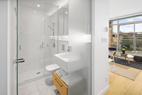 bagno bianco con doccia e lavandino di Iconic Downtown Living! 1bedroom, Gym, Rooftop Patio. a Victoria