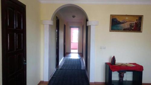 un pasillo abovedado con una mesa roja y una puerta en Gia Home, en Kobuleti