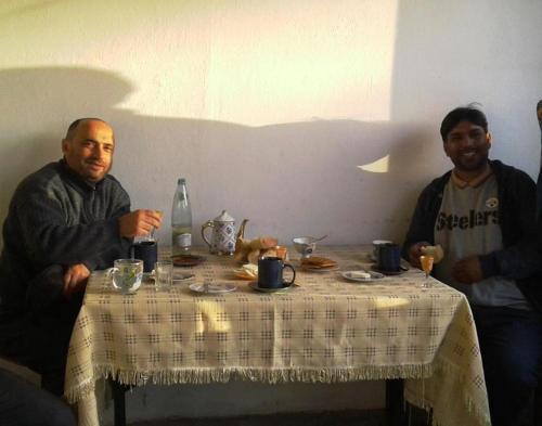 two men sitting at a table with a table cloth at Gia Home in K'obulet'i