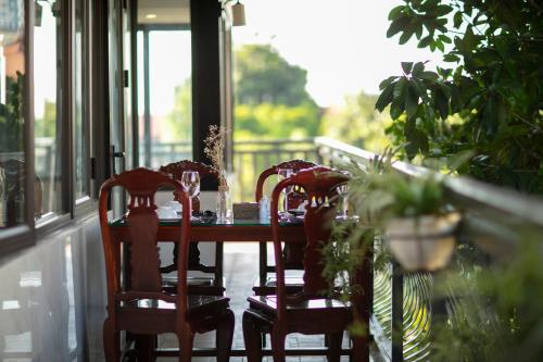 a dining room table with three chairs and a window at Nam Hai Hotel in Hanoi