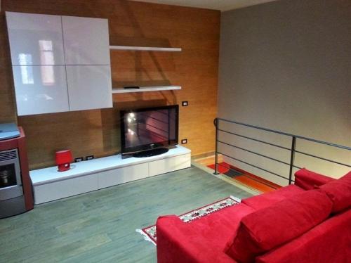 a living room with a red couch and a tv at B&B Rampante in Piana degli Albanesi