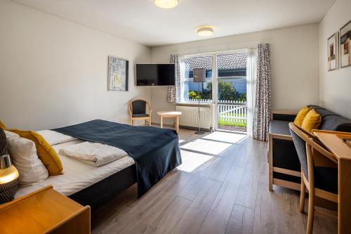 - une chambre avec un lit et une salle à manger dans l'établissement Fjordgaarden - Kurbad - Hotel - Konference, à Ringkøbing