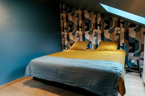 a bedroom with a bed and a blue wall at Le rétro chic - Grand Duplex pour 6 dans le centre in Liège