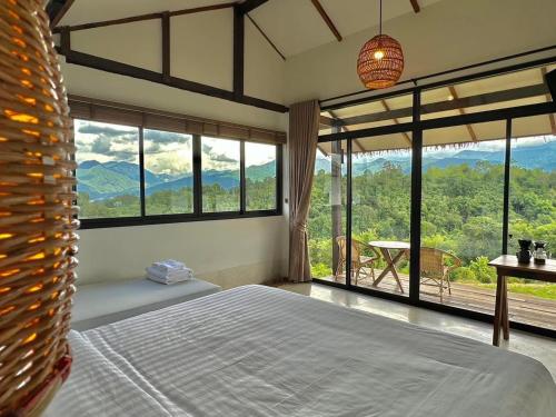 a bedroom with a bed and a view of the mountains at Utopua Resort ยูโทปัวว์ รีสอร์ท in Pua