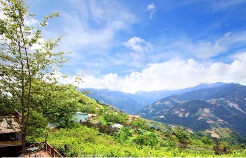 vistas a un valle con montañas en el fondo en Chingjing New Paradise B&B, en Renai