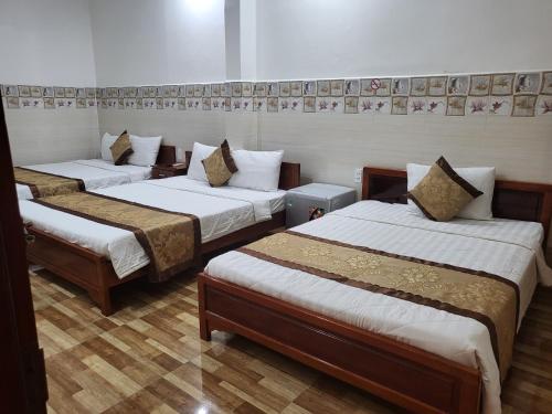Sơn Tùng Motel في Ấp Trà Kha: غرفة بثلاث اسرة في غرفة