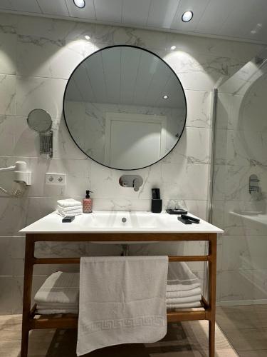 a bathroom with a sink and a mirror at Apartamentos Turísticos La Plaza in Chipiona
