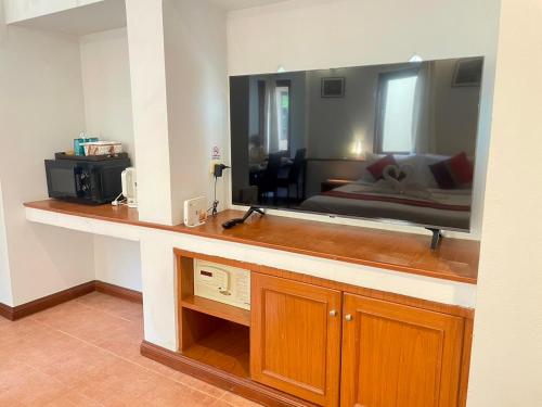 a living room with a large mirror over a counter at Samui Honey Cottages Beach Resort - SHA Extra Plus in Choeng Mon Beach