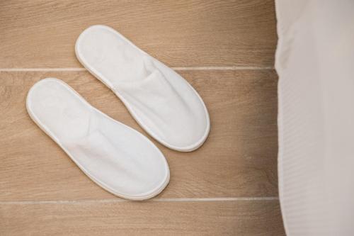 a pair of white shoes sitting on the floor at Almond Hotel - Adults only in Neve Ilan