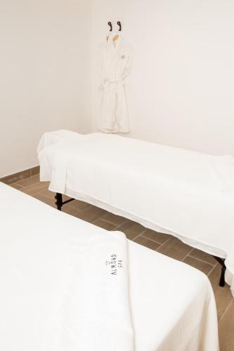 a bed in a room with white sheets at Almond Hotel - Adults only in Neve Ilan
