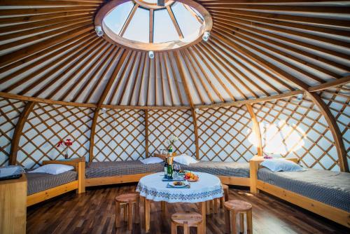 a room with benches and a table in a yurt at Glory Resort Mongolia in Nalayh