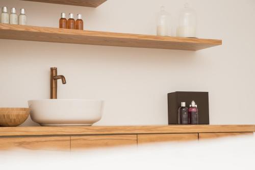 a kitchen with wooden shelves and a sink at Almond Hotel - Adults only in Neve Ilan
