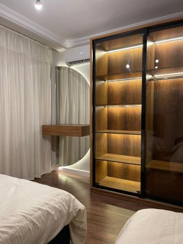 a bedroom with a large glass closet with a bed at شقة فندقيه معقمه للإجار اليومي او الشهري in Cairo