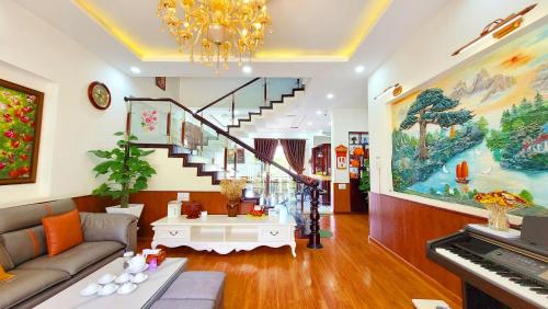 uma sala de estar com um sofá e um piano em Villa H Flower Đà Lạt em Da Lat
