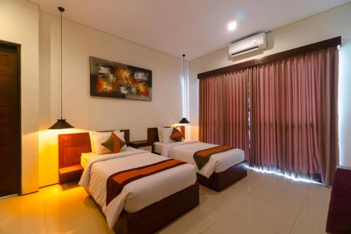 a hotel room with two beds and a window at Villa C31 Seminyak in Seminyak