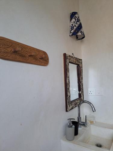 a bathroom with a sink and a mirror on the wall at Pwani House - Lamu Seafront in Lamu