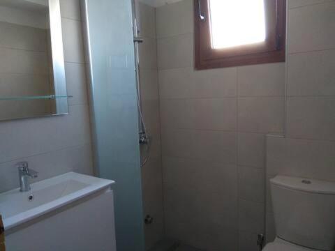 a bathroom with a sink and a toilet and a window at Patra's Apartments Kleopatra and Komissa in Poseidónion