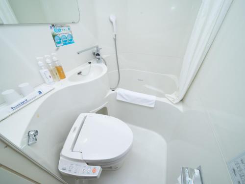 uma casa de banho com um WC branco e um espelho. em Super Hotel Kitami em Kitami