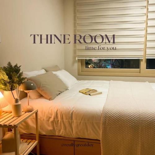 - une chambre dotée d'un lit et d'un panneau représentant l'heure sur le mur dans l'établissement Thine Room, à Suwon