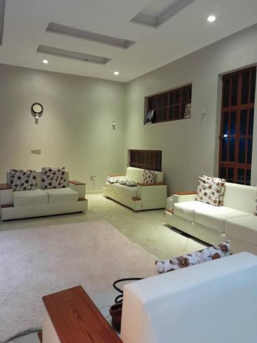 a large living room with couches and a table at Simba Villa in Arusha