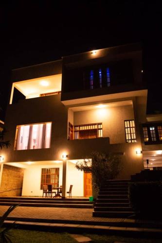 a large building with a staircase in front of it at night at Simba Villa in Arusha