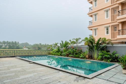 a swimming pool in front of a building at HideAway 2BHK Villa Style Apartment - Stay To Unwind in Old Goa