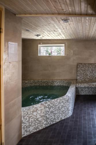 a large bath tub in a room with a window at Veldemani puhkemaja in Vaibla