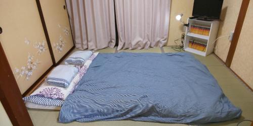 a bed with a blue blanket in a room at Yagisawa Corp 103 - Vacation STAY 33494v in Nikko