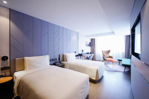 a hotel room with two beds and a table at Atour S Hotel Guangzhou Tianhe Taikoo Hui in Guangzhou