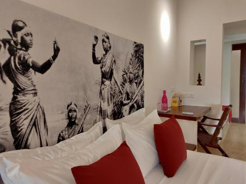 a bedroom with a bed and a mural of men at Mangala Heritage by LuxUnlock Private Villas in Tirukkannapuram