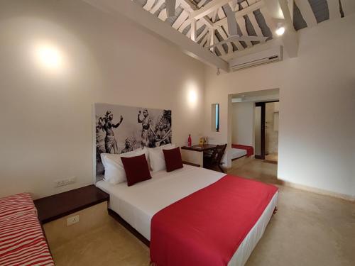 ein Schlafzimmer mit einem großen weißen Bett mit einer roten Decke in der Unterkunft Mangala Heritage by LuxUnlock Private Villas in Tirukkannapuram