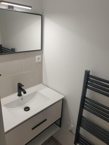 une salle de bain avec un lavabo et un miroir dans l'établissement Mezza'Nîmes, à Nîmes