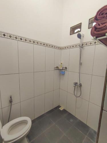 a bathroom with a toilet and a shower at Pondok Selip Guesthouse in Krambitan