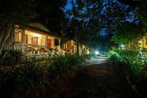 une maison éclairée la nuit dans une rue dans l'établissement Machan Country Villa, à Chitwan