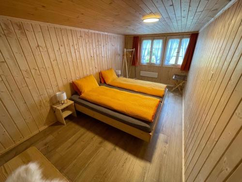 een kleine slaapkamer met een bed met gele lakens bij Alpenchalet Haldeli Gstaad Fereienwohnung im 1-Stock in Gstaad