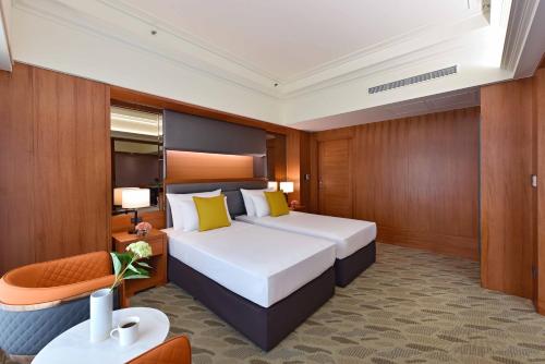 a hotel room with a large bed and a chair at Fullon Poshtel - Linkou in Guishan