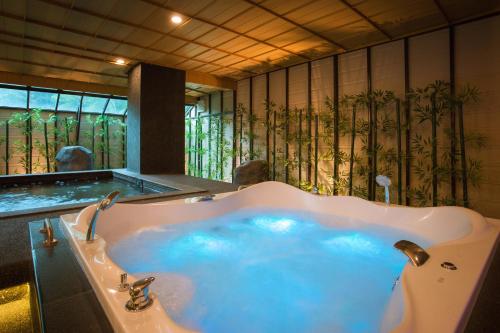 uma grande banheira com água azul na casa de banho em Hillside Residence Khaoyai em Mu Si