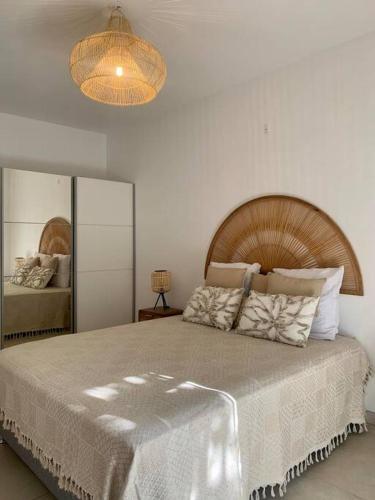 a bedroom with a large bed with a wooden headboard at Villa Rosa Palma 10 personnes piscine chauffée à St Gilles les bains in Saint-Paul