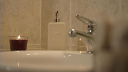 a soap dispenser sitting next to a sink with a candle at Mountain Retreat in Troodos
