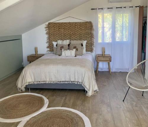 a bedroom with a large bed with two tables and two windows at Villa Rosa Palma 10 personnes piscine chauffée à St Gilles les bains in Saint-Paul