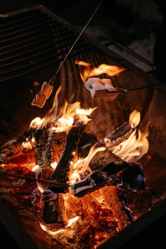 a grill with a bunch of fire in it at Lapland Hotels Ounasvaara Chalets in Rovaniemi